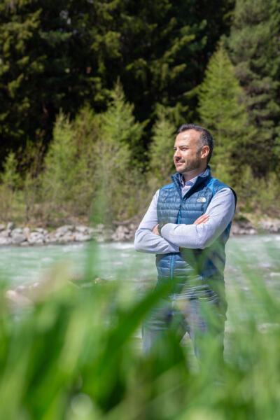 Giovan Battista Buzzetti steht am Inn und schaut am Betrachter vorbei in die Landaschaft